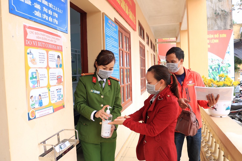 Lực lượng CAQ Đồ Sơn tuyên truyền, hướng dẫn công dân sử dụng dung dịch rửa tay sát khuẩn trước khi vào làm việc