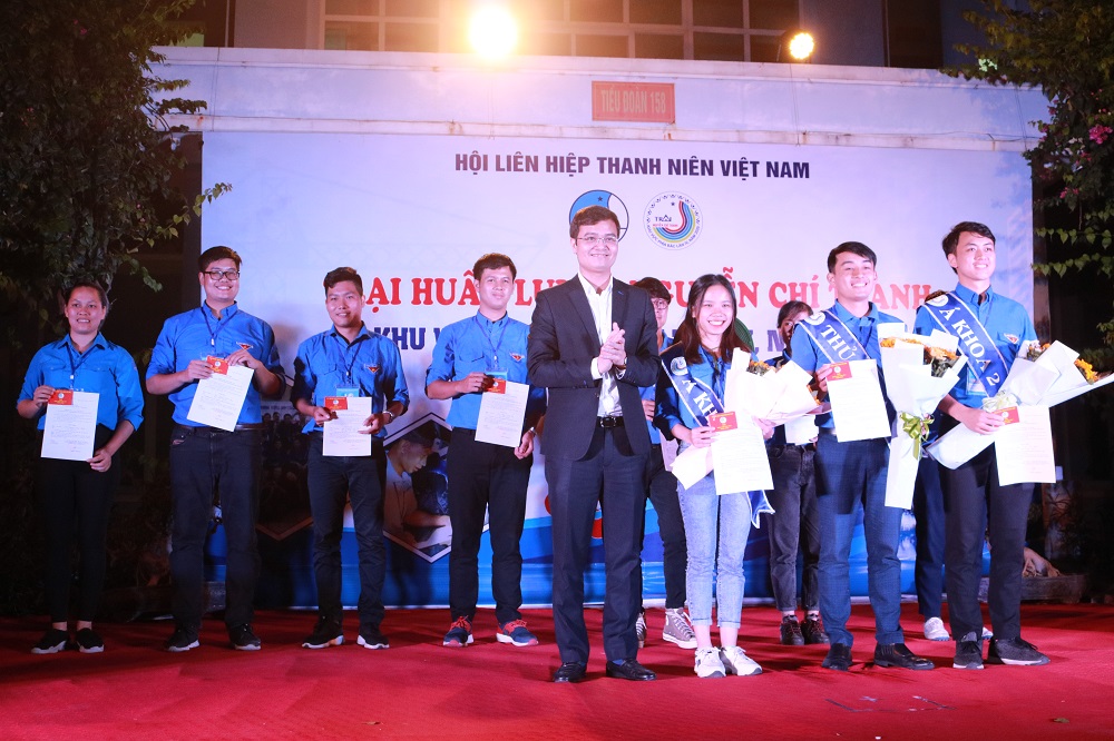 Đồng chí Bùi Quang Huy - Bí thư Ban Chấp hành Trung ương Đoàn TNCS Hồ Chí Minh, Chủ tịch Hội Sinh viên Việt Nam trao dải băng danh dự, tặng hoa cho Thủ khoa và 2 Á khoa của Trại Nguyễn Chí Thanh khu vực phía Bắc lần thứ 4, năm 2020